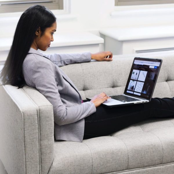 woman-with-laptop-on-couch-min